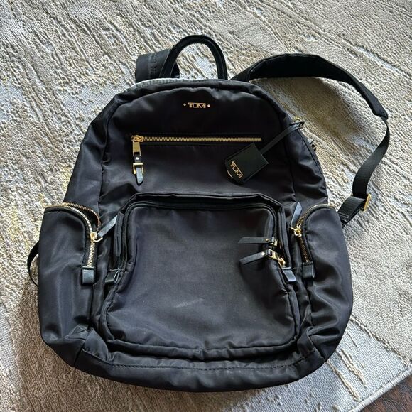Tumi Carson backpack black with gold hardware in GUC has flaw on handle